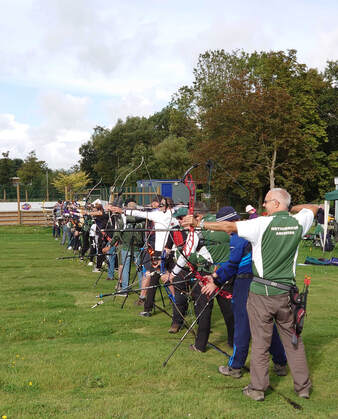 An image of many club members on the shooting field